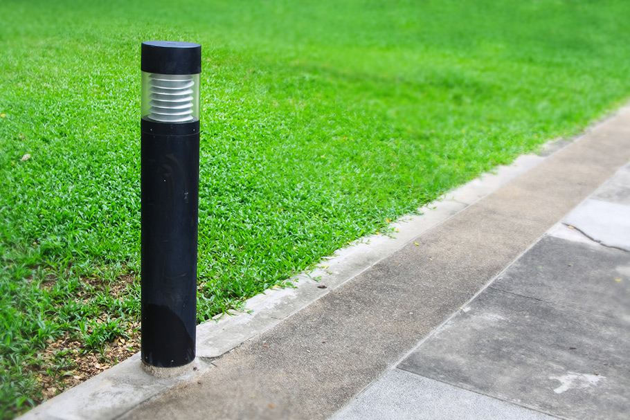 A beacon bollard light next to a field