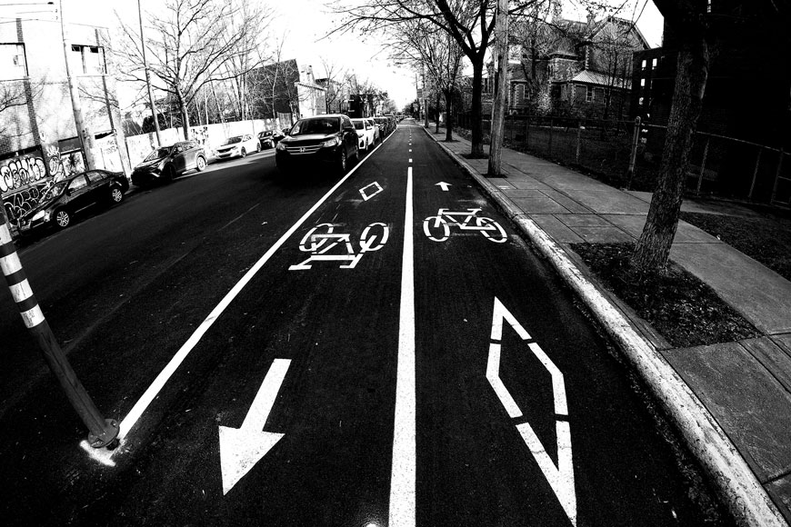 A black and white fish-eye photo shows a bidirectional separated bike lane