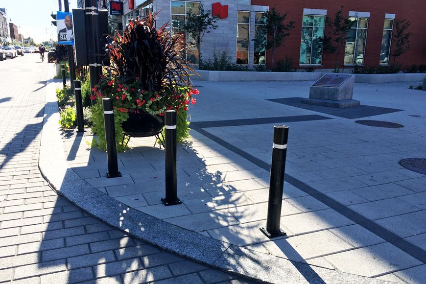 Three polyurethane black bollards protect pedestrian space