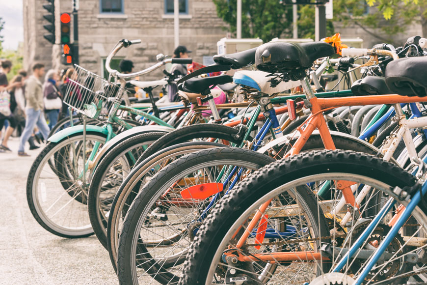 A cluster of bikes are parked outside of a university building in Montreal