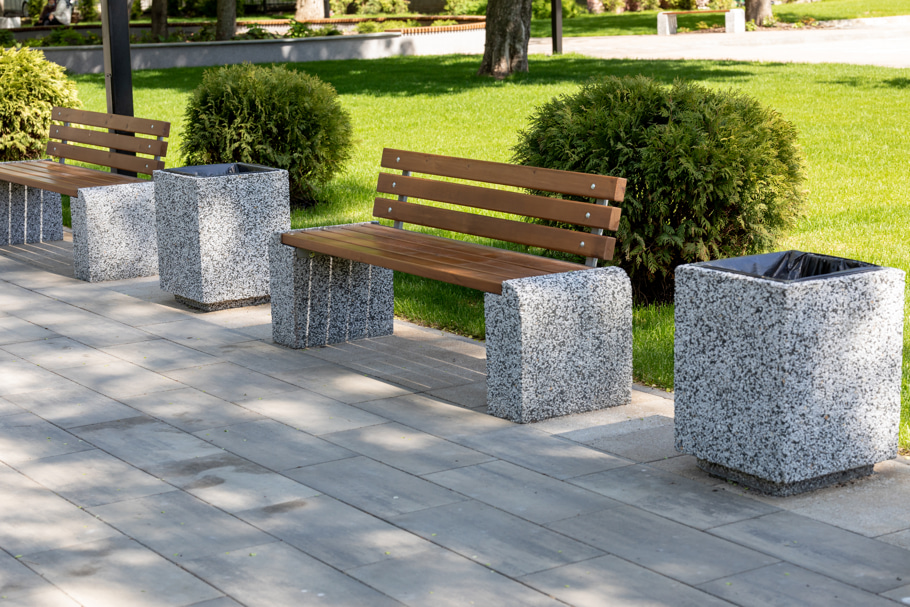 Benches and garbage bins placed along a walking path.