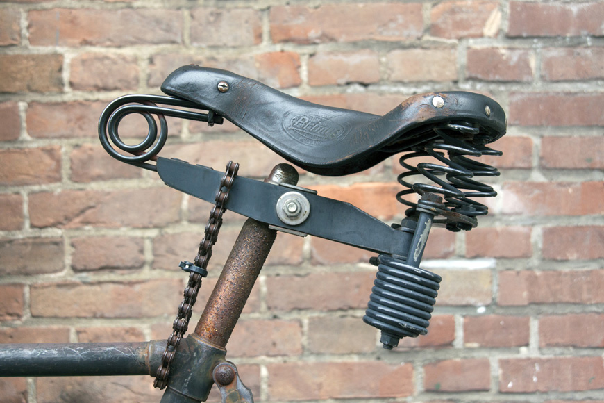 A custom bike seat on an older bike is locked on with bicycle chain