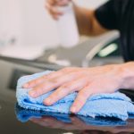 Close up on a man applying ceramic coating on a black vehicle