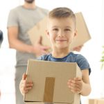 family carrying moving boxes